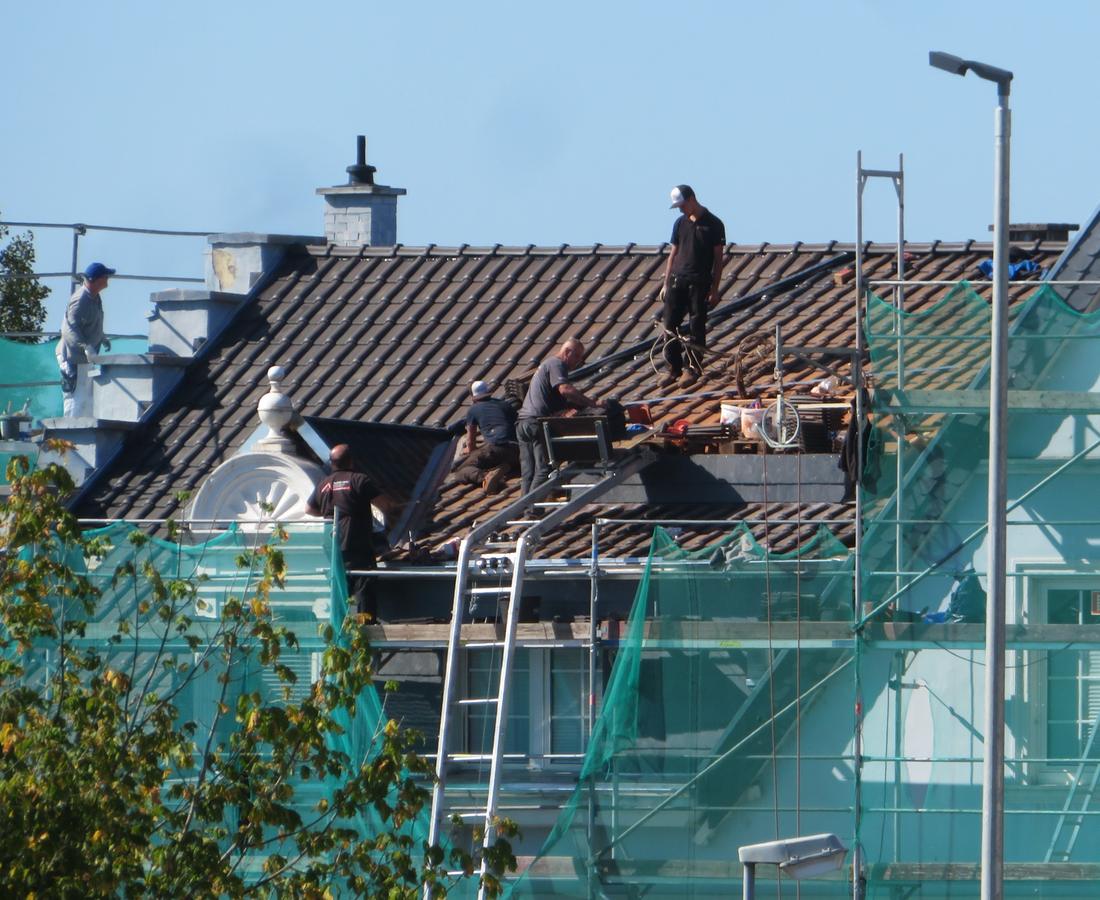 Dachdecker bei der Arbeit auf einem eingerüsteten Dach